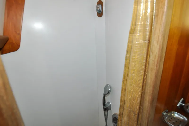 Night Train Yacht Photos Pics Shower area in 1986 Hinckley Sou'wester 51 yacht with wooden accents and curtain.