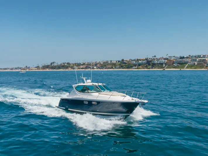 Worked The Plan Yacht Photos Pics 2009 Tiara Yachts 3900 Sovran cruising on blue ocean near coastal cityscape.