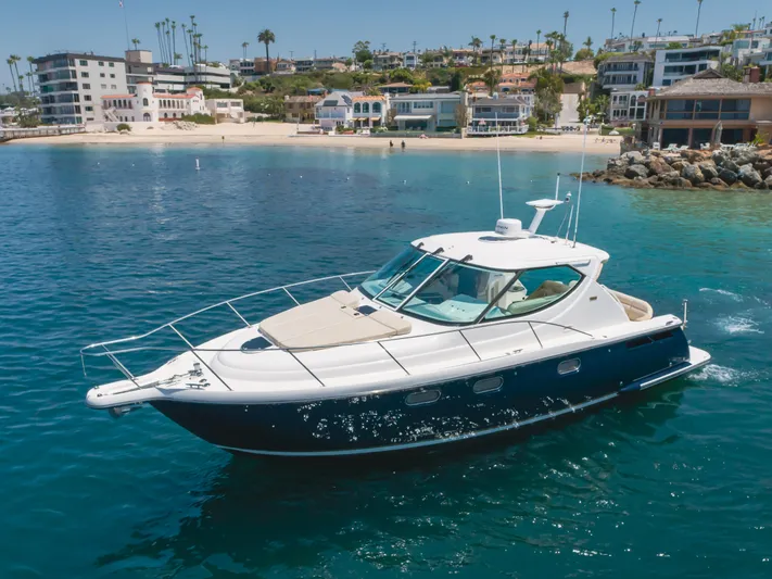 Worked The Plan Yacht Photos Pics 2009 Tiara Yachts 3900 Sovran cruising near a scenic coastal town.