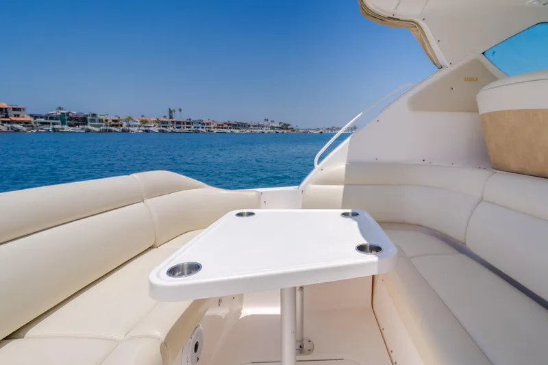 Worked The Plan Yacht Photos Pics 2009 Tiara Yachts 3900 Sovran interior with seating and table, overlooking a scenic waterfront.