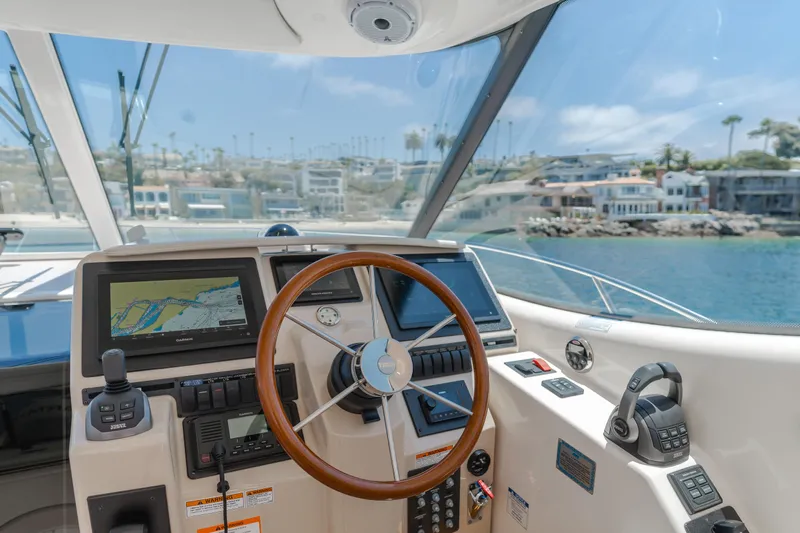 Worked The Plan Yacht Photos Pics 2009 Tiara Yachts 3900 Sovran helm with navigation screens and steering wheel, coastal view.