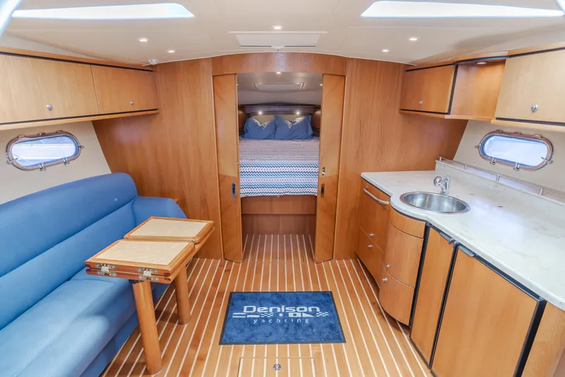 Worked The Plan Yacht Photos Pics 2009 Tiara Yachts 3900 Sovran interior with wood finish, blue seating, and compact kitchenette.