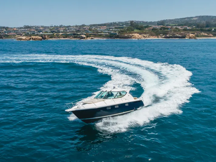 Worked The Plan Yacht Photos Pics 2009 Tiara Yachts 3900 Sovran cruising on blue ocean near scenic coastline.