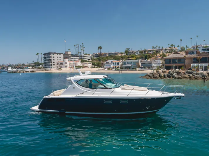 Worked The Plan Yacht Photos Pics 2009 Tiara Yachts 3900 Sovran cruising near a coastal town with clear blue water.