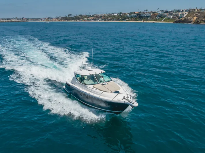 Worked The Plan Yacht Photos Pics 2009 Tiara Yachts 3900 Sovran cruising on open blue water near coastline.