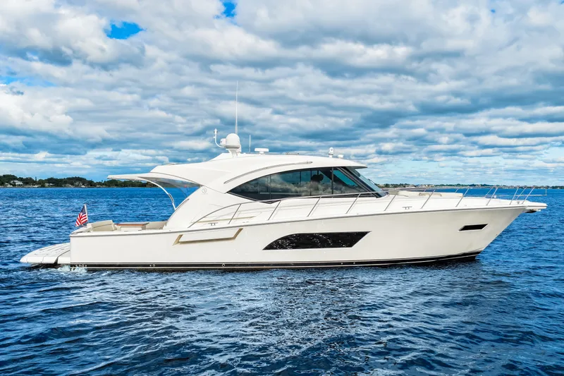 Escape Pod Yacht Photos Pics 2015 Riviera 565 SUV yacht cruising on open water under a cloudy sky.