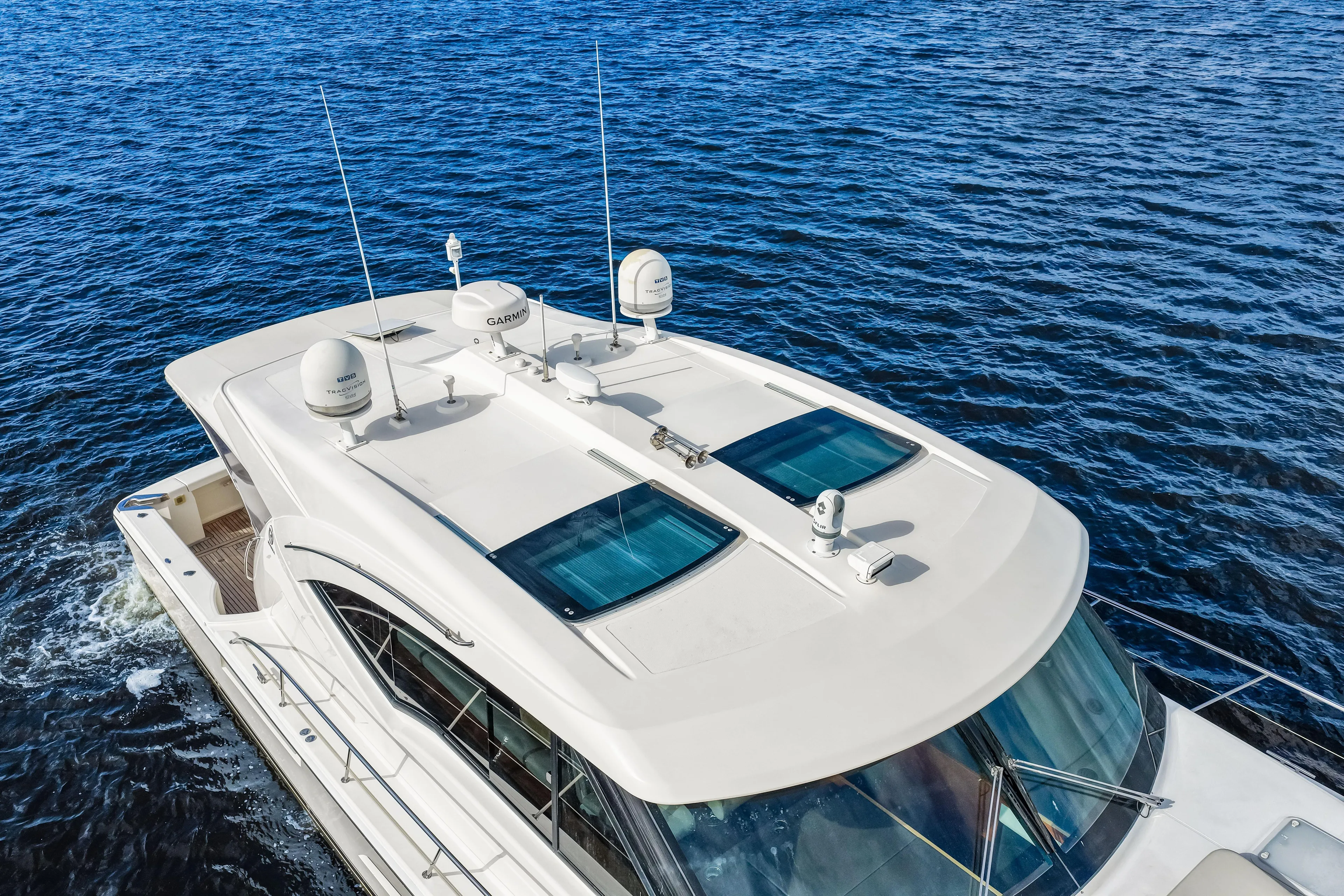 Escape Pod Yacht Photos Pics 2015 Riviera 565 SUV yacht cruising on open water, aerial view.