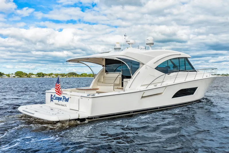 Escape Pod Yacht Photos Pics 2015 Riviera 565 SUV yacht cruising on open water under a cloudy sky.