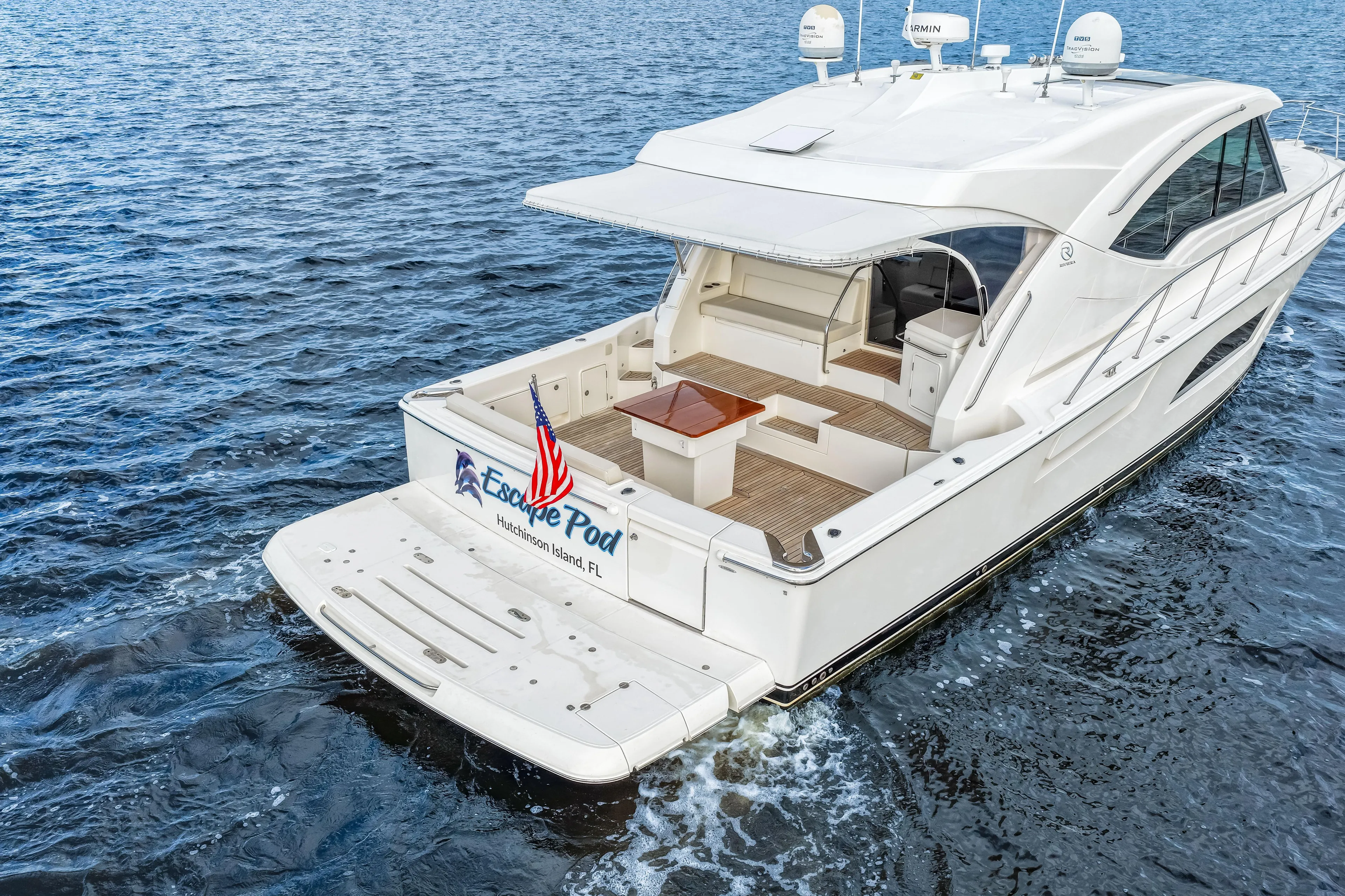 Escape Pod Yacht Photos Pics 2015 Riviera 565 SUV yacht on water, rear view with American flag.