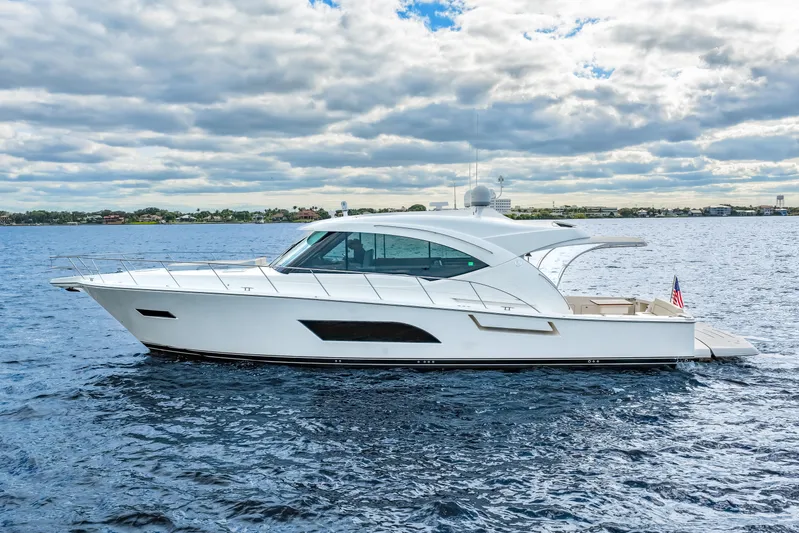 Escape Pod Yacht Photos Pics 2015 Riviera 565 SUV yacht cruising on open water under cloudy skies.
