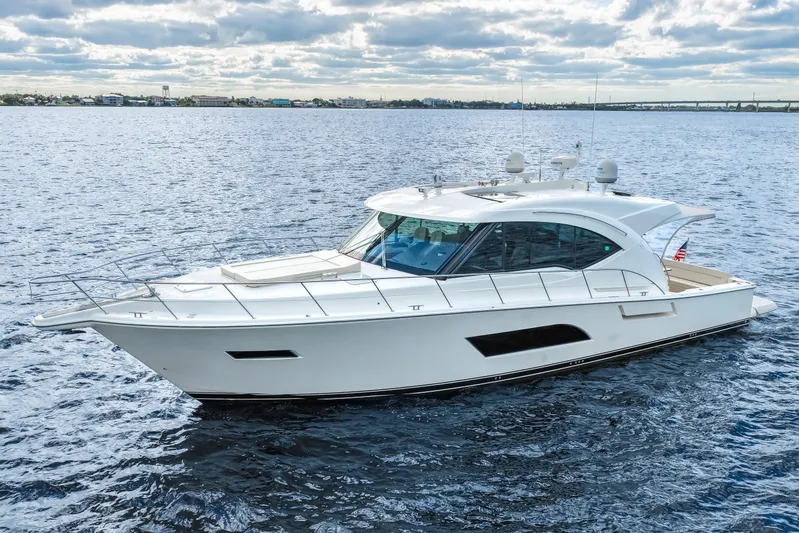 Escape Pod Yacht Photos Pics 2015 Riviera 565 SUV yacht cruising on open water under a cloudy sky.