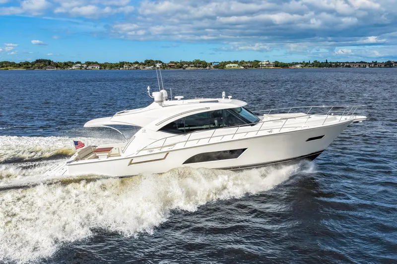 Escape Pod Yacht Photos Pics 2015 Riviera 565 SUV cruising on open water under a partly cloudy sky.