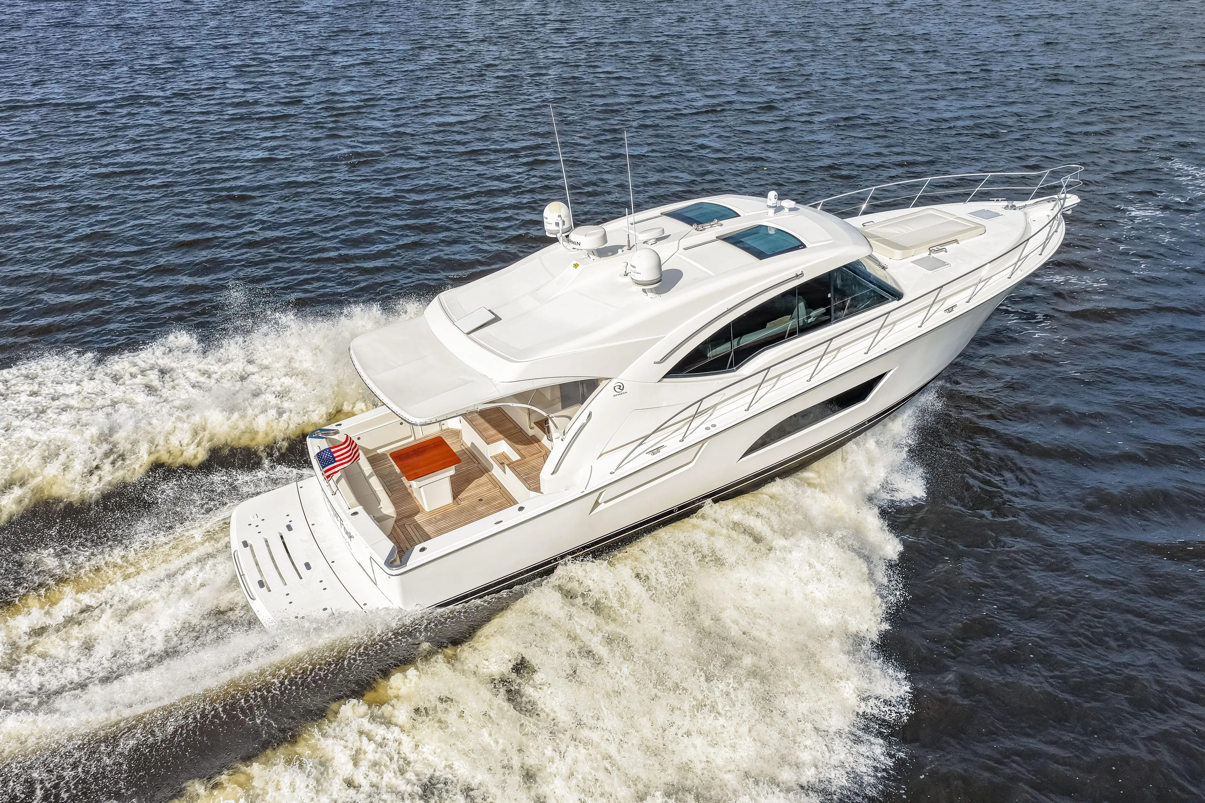 Escape Pod Yacht Photos Pics 2015 Riviera 565 SUV yacht cruising on open water, rear view.