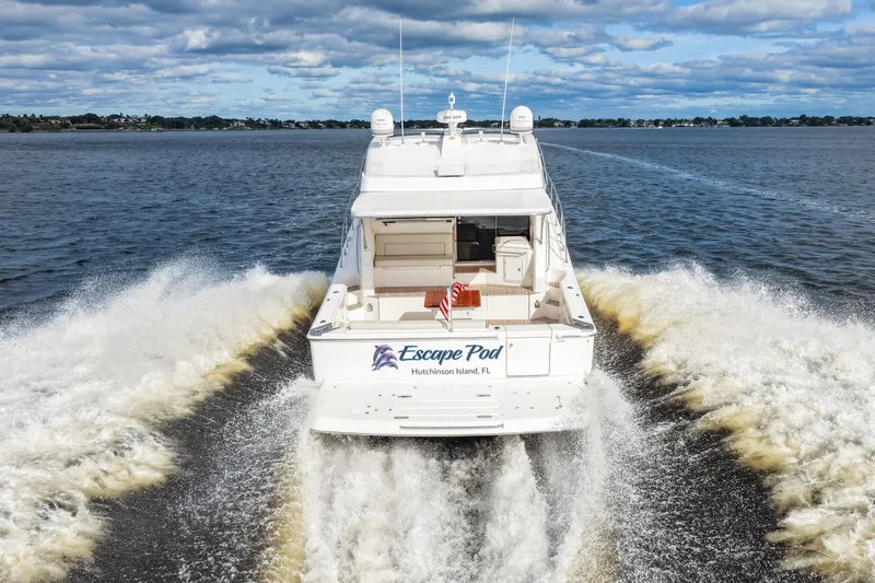 Escape Pod Yacht Photos Pics 2015 Riviera 565 SUV cruising on open water, rear view, "Escape Pod" name visible.