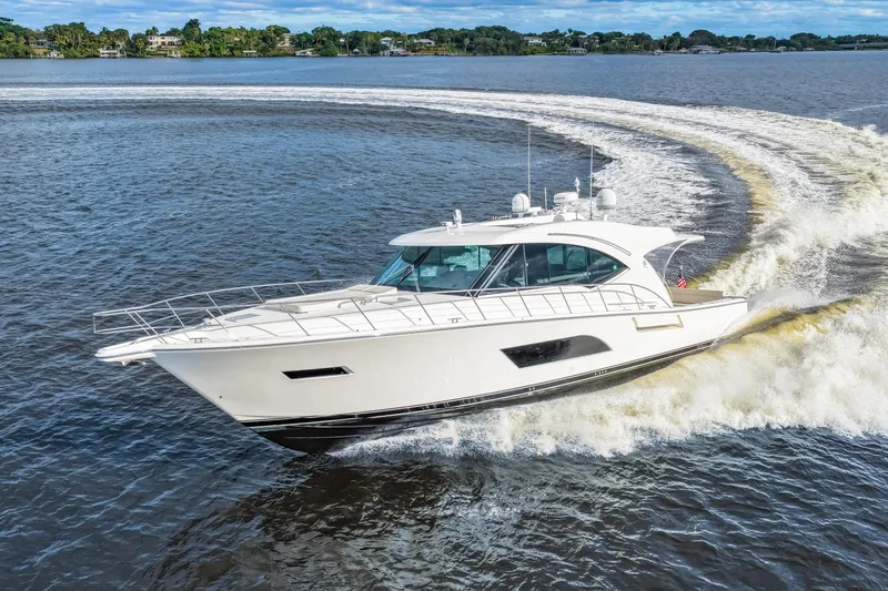 Escape Pod Yacht Photos Pics 2015 Riviera 565 SUV yacht cruising on open water, creating a dynamic wake.