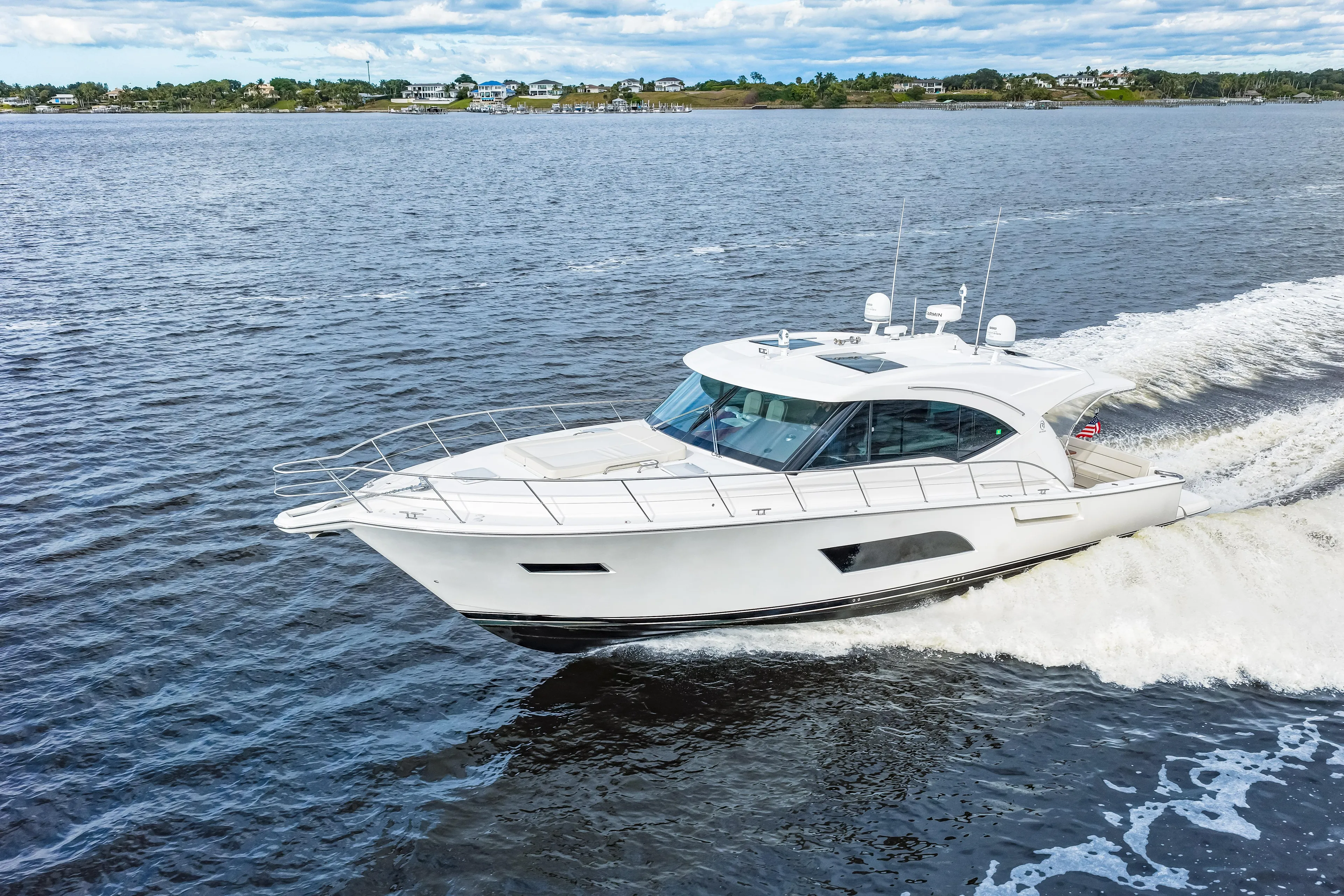 Escape Pod Yacht Photos Pics 2015 Riviera 565 SUV cruising on open water, showcasing sleek design and luxury features.