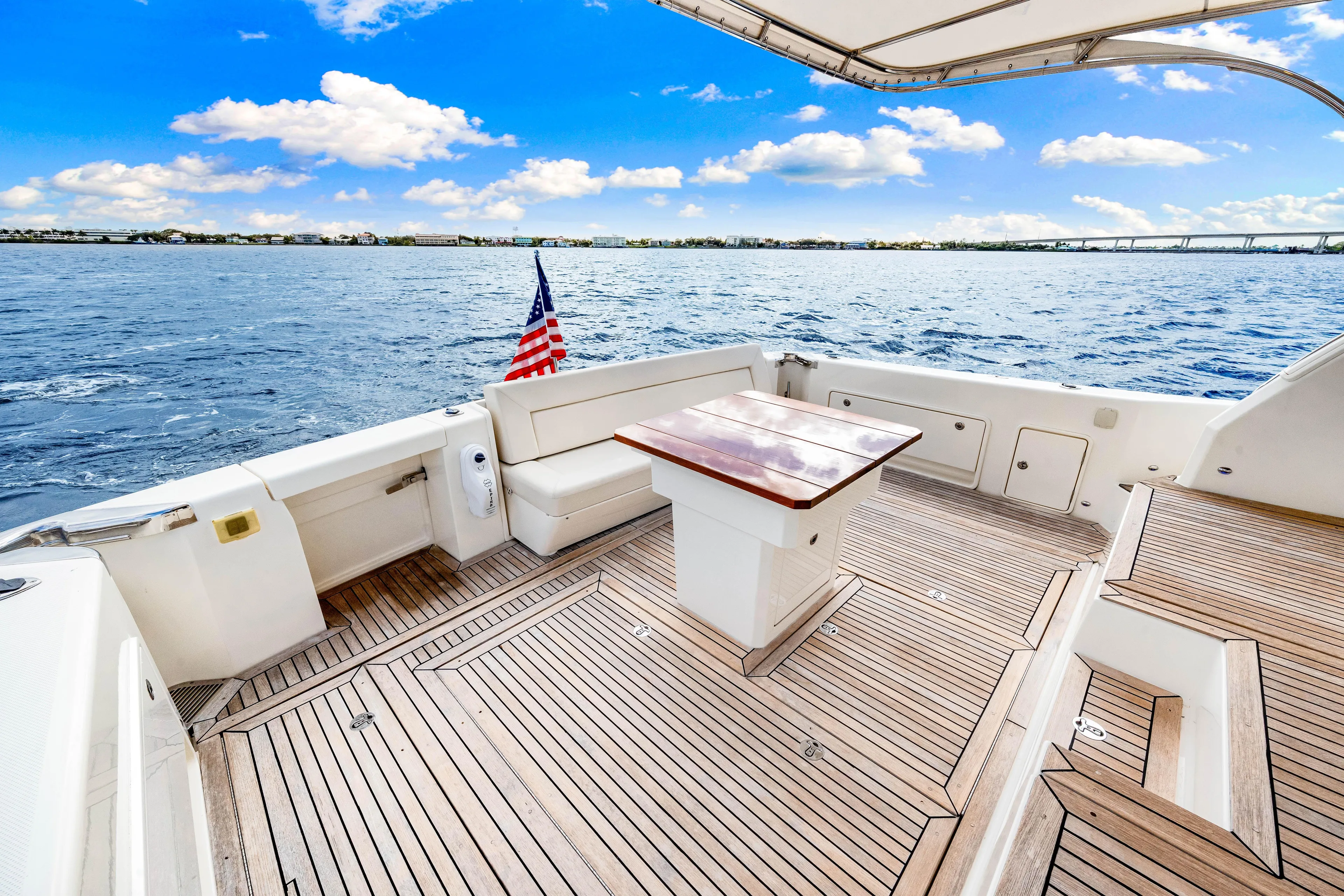 Escape Pod Yacht Photos Pics 2015 Riviera 565 SUV yacht deck with seating, table, and ocean view.