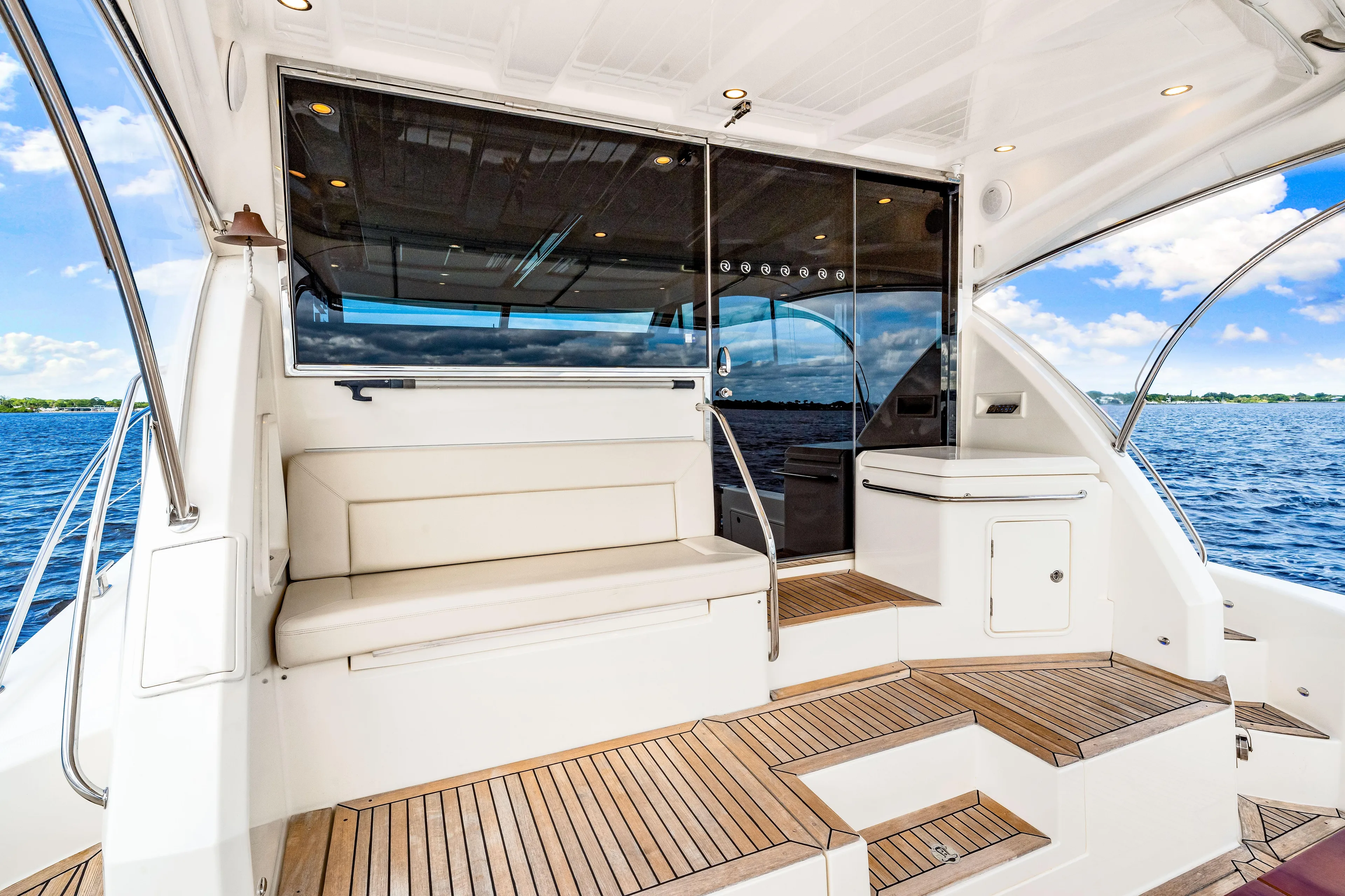 Escape Pod Yacht Photos Pics 2015 Riviera 565 SUV yacht interior with seating, wooden flooring, and ocean view.