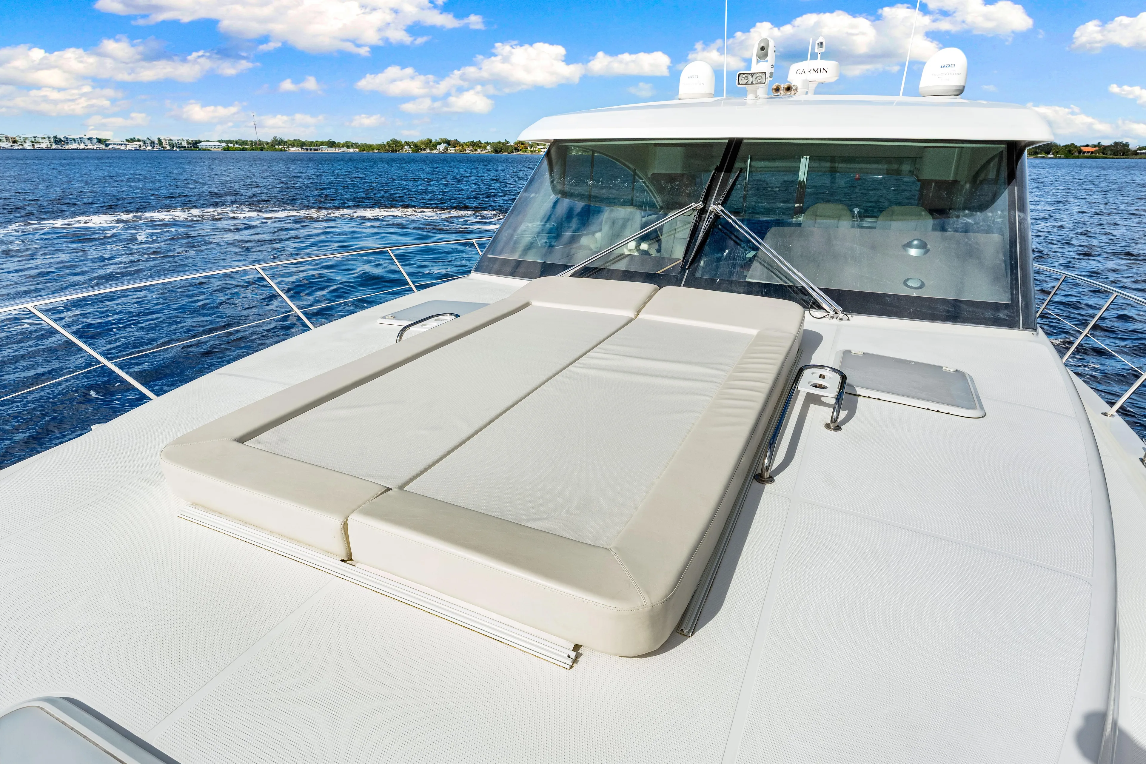 Escape Pod Yacht Photos Pics 2015 Riviera 565 SUV yacht with sunbed on deck, cruising on a sunny day.