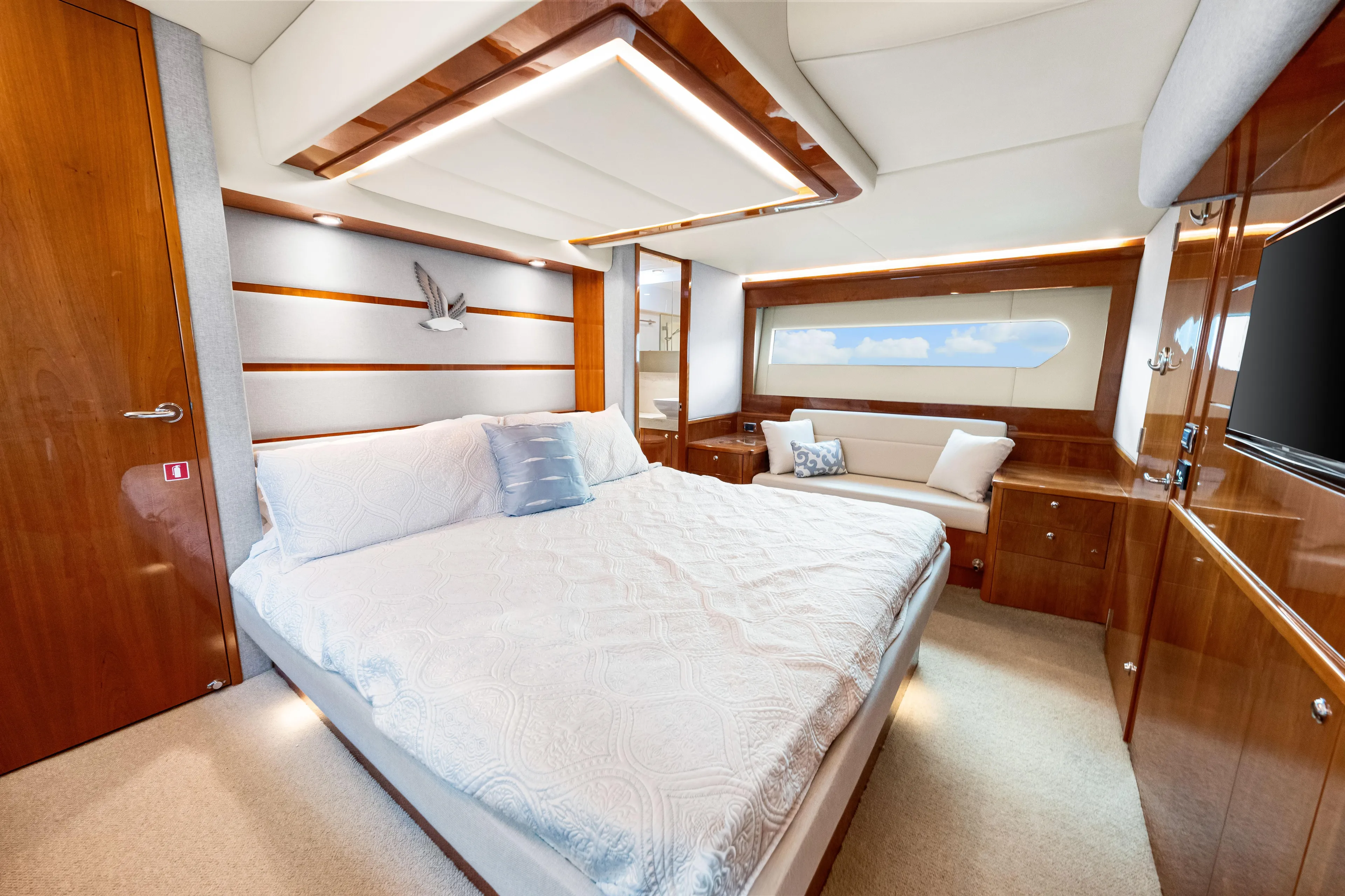 Escape Pod Yacht Photos Pics Luxurious bedroom interior of 2015 Riviera 565 SUV yacht with elegant wood finishes.