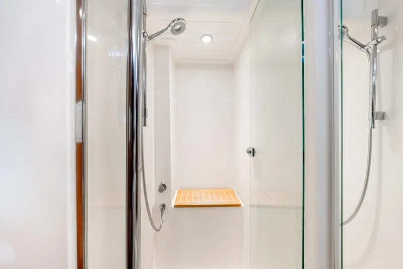 Escape Pod Yacht Photos Pics Luxurious shower in 2015 Riviera 565 SUV yacht with modern fixtures and wooden bench.