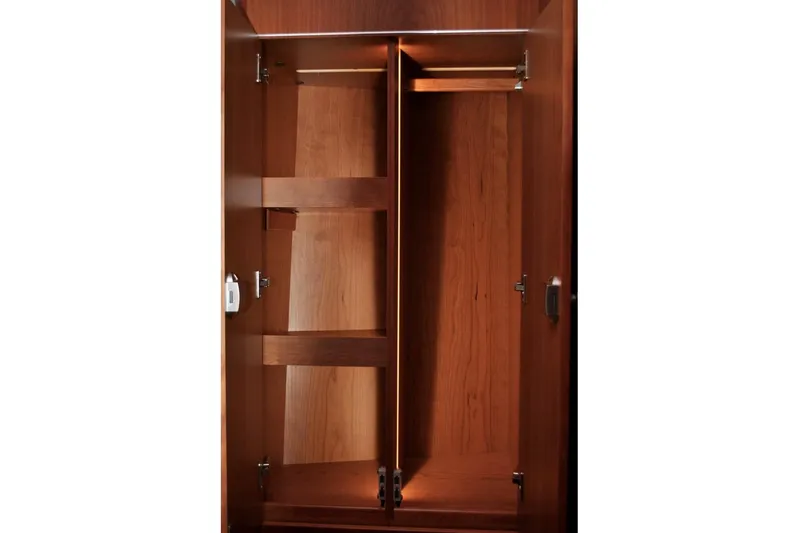 First Light Yacht Photos Pics Wooden interior closet of 2017 Hanse 505 yacht, featuring shelves and hanging space.