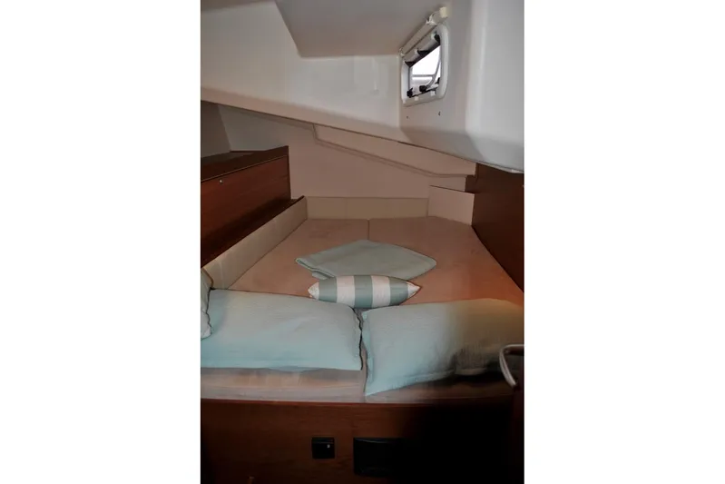First Light Yacht Photos Pics Cozy cabin interior of 2017 Hanse 505 yacht with cushions and porthole.