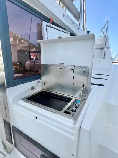 Sea Dog Yacht Photos Pics Outdoor grill on a 2023 Bali 4.6 yacht deck, near a window and stairs.