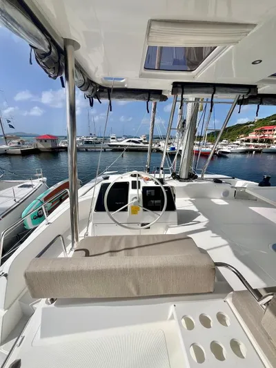 Sea Dog Yacht Photos Pics Modern 2023 Bali 4.6 yacht interior with steering wheel, docked at marina under clear sky.