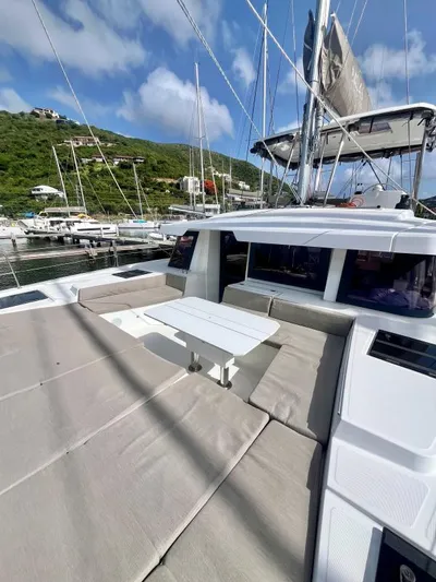 Sea Dog Yacht Photos Pics 2023 Bali 4.6 yacht with spacious deck seating and table, docked in a scenic marina.