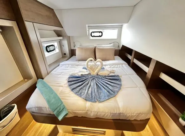 Sea Dog Yacht Photos Pics Luxurious cabin interior of 2023 Bali 4.6 yacht with elegant bed and towel decor.