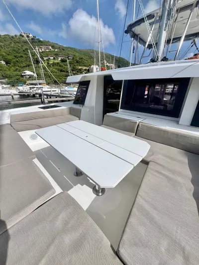 Sea Dog Yacht Photos Pics 2023 Bali 4.6 yacht with outdoor seating, docked in a scenic marina.