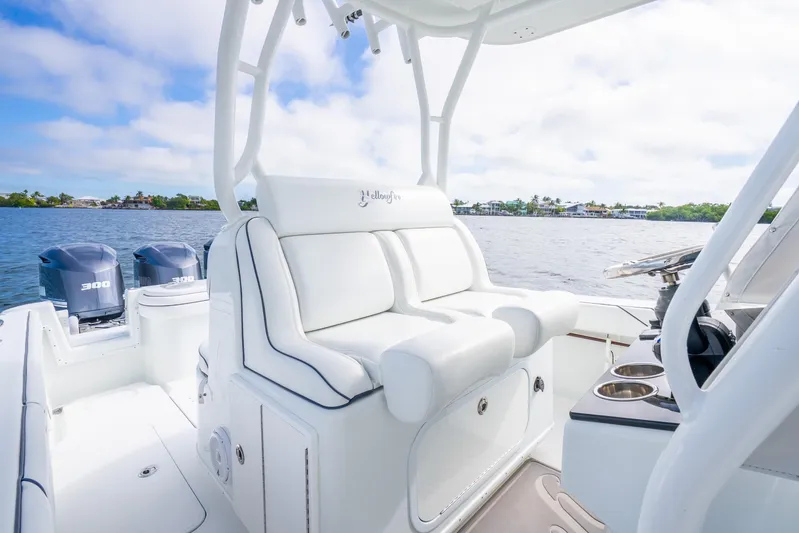  Yacht Photos Pics 2016 Yellowfin 36 Offshore boat interior with white seating and dual engines on a sunny day.