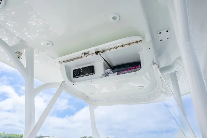  Yacht Photos Pics 2016 Yellowfin 36 Offshore boat storage compartment with electronic equipment, under a clear blue sky.