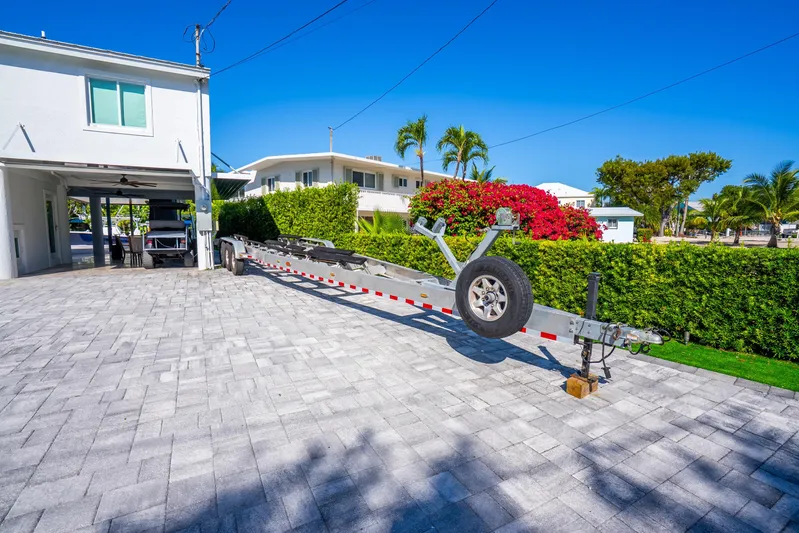  Yacht Photos Pics Driveway with boat trailer for 2016 Yellowfin 36 Offshore, surrounded by tropical landscaping.