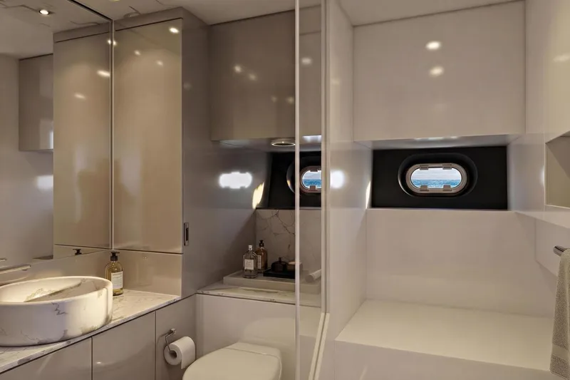  Yacht Photos Pics Luxurious bathroom interior of 2026 Ladenstein L48 MIAMI yacht with modern fixtures and porthole windows.