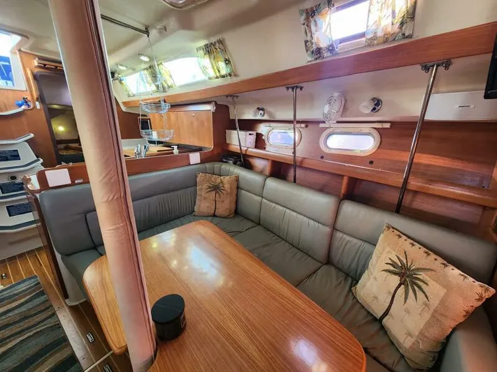 Soleyah Yacht Photos Pics Interior of 2007 Catalina 387 sailboat with cozy seating and wooden table.
