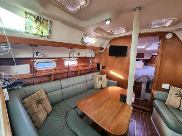 Soleyah Yacht Photos Pics Interior of 2007 Catalina 387 sailboat with cozy seating and wooden table.