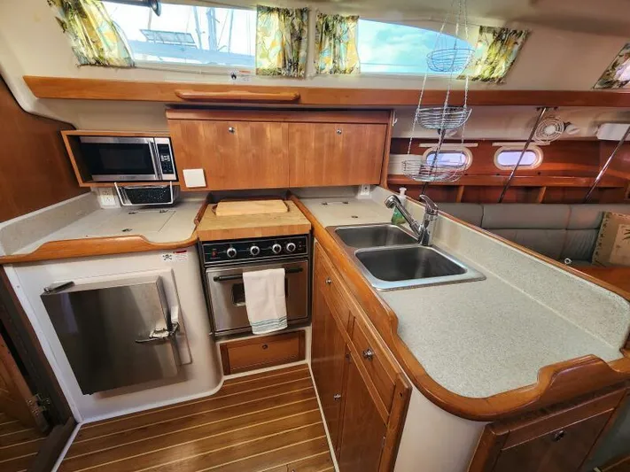 Soleyah Yacht Photos Pics Catalina 387 yacht kitchen interior, 2007 model, featuring wood cabinetry and modern appliances.