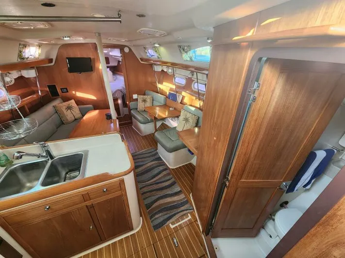 Soleyah Yacht Photos Pics Interior of 2007 Catalina 387 sailboat with wood finish, kitchen, and seating area.