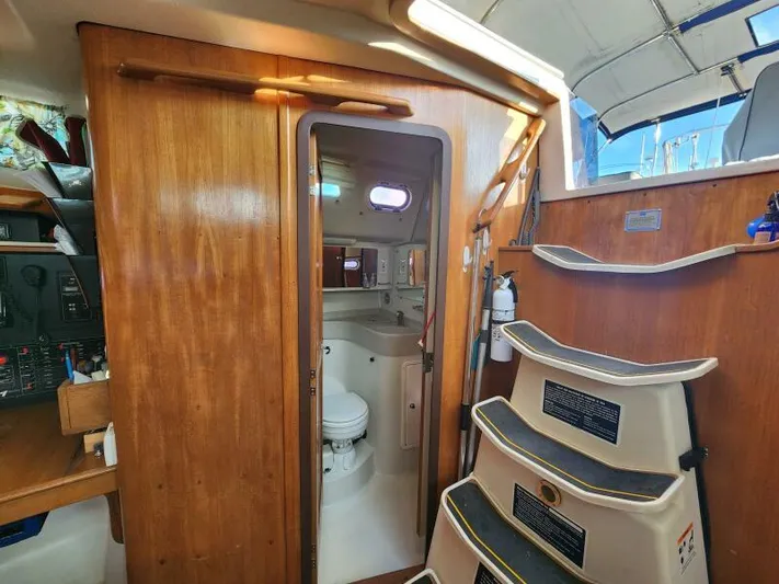 Soleyah Yacht Photos Pics Interior of 2007 Catalina 387 sailboat with wooden cabinetry and compact bathroom.