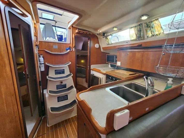 Soleyah Yacht Photos Pics Interior of 2007 Catalina 387 sailboat with modern kitchen and wooden cabinetry.