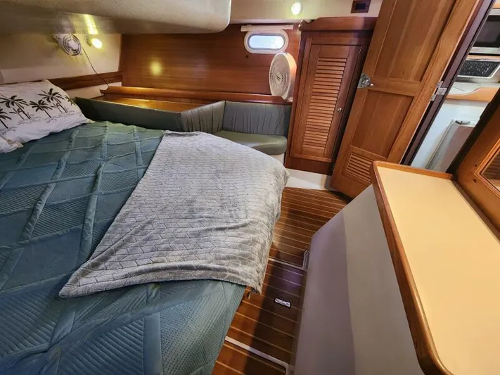 Soleyah Yacht Photos Pics Cozy cabin interior of 2007 Catalina 387 sailboat with bed and wooden furnishings.