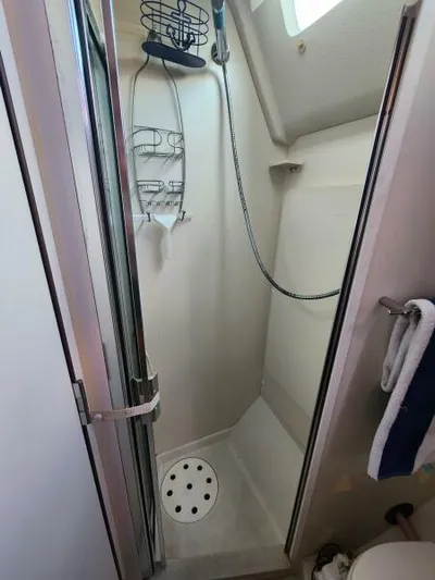Soleyah Yacht Photos Pics Shower area in 2007 Catalina 387 sailboat with glass door and wall-mounted fixtures.