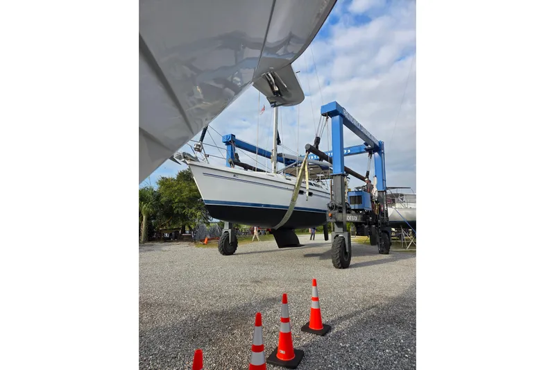 Soleyah Yacht Photos Pics 2007 Catalina 387 sailboat being lifted by a blue crane in a boatyard.