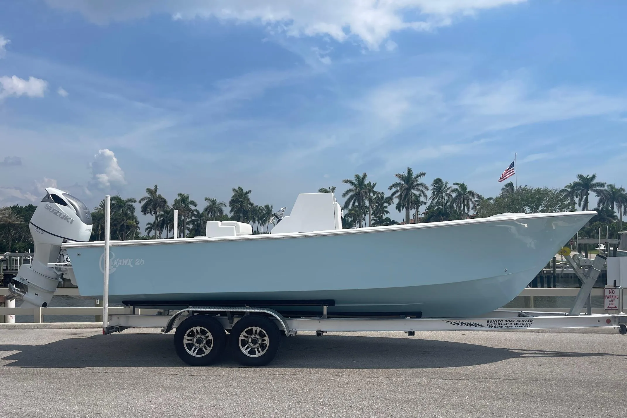 2026 C-Hawk 26 Center Console boat on trailer, palm trees and American flag in background.