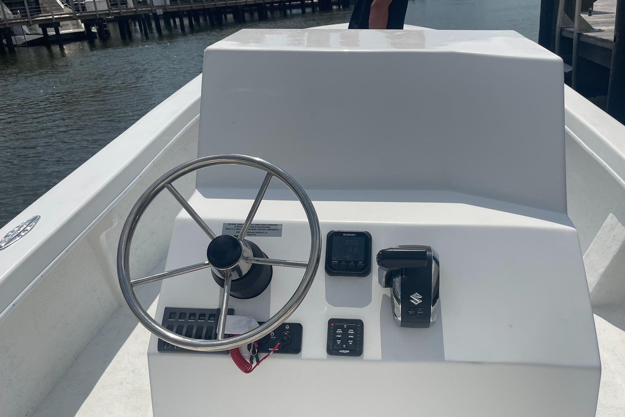 2026 C-Hawk 26 Center Console boat steering wheel and controls by the water.