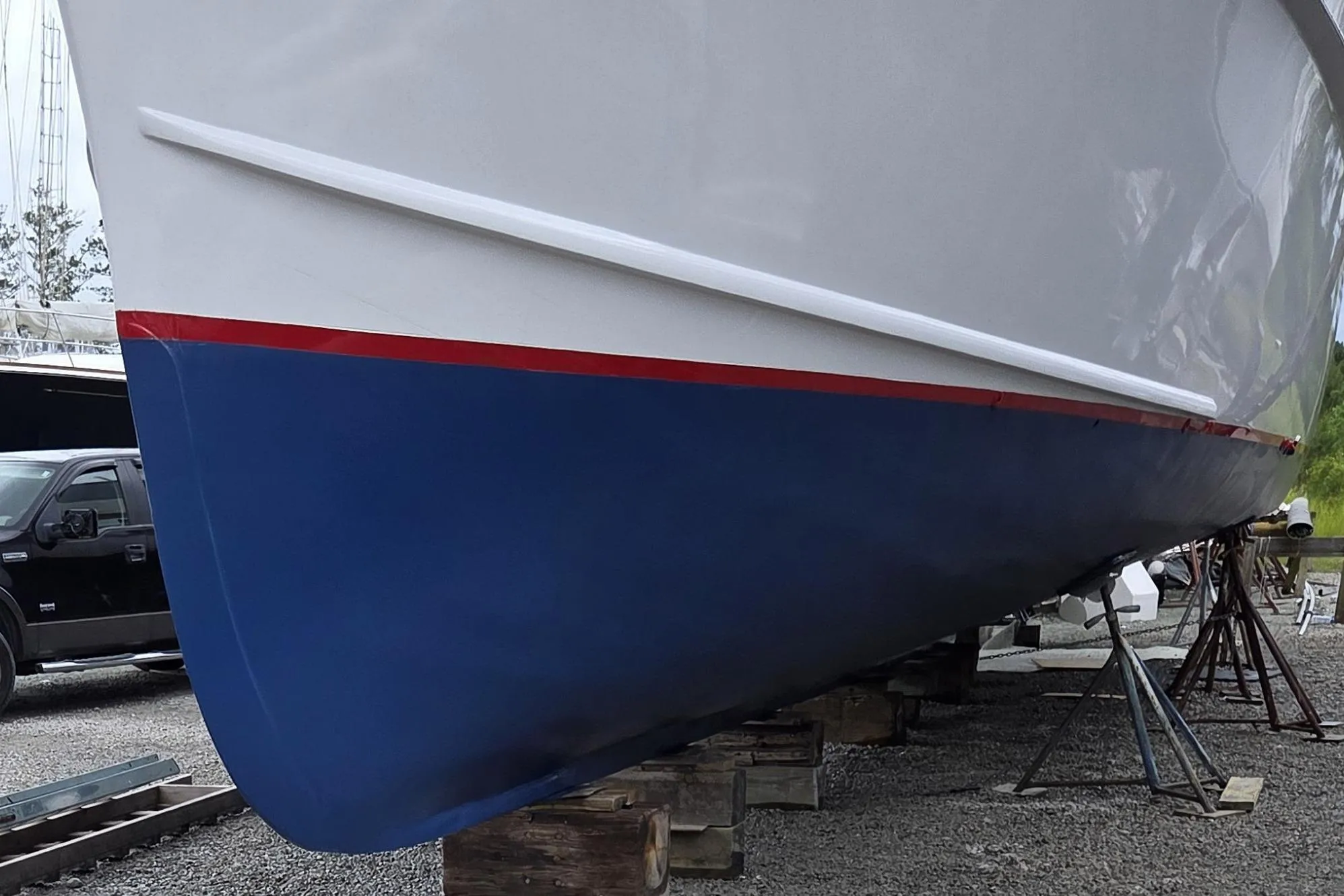 1966 Trumpy 55 boat hull with blue and white paint, displayed on supports.