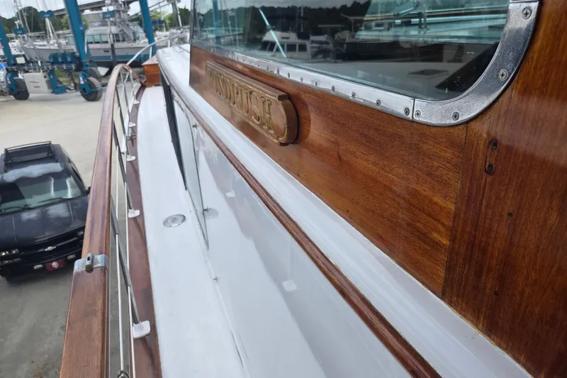 Windrush Yacht Photos Pics 1966 Trumpy 55 yacht with polished wood finish and metal accents in a marina setting.