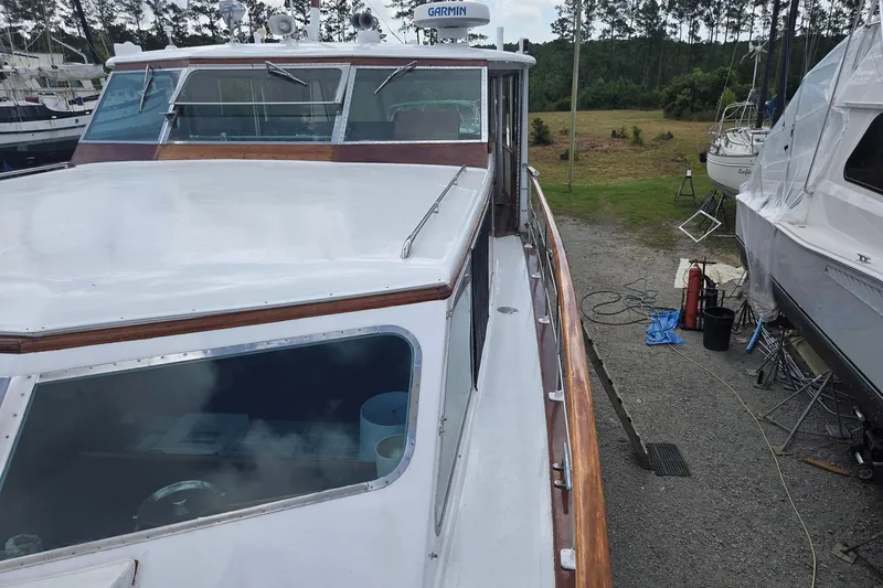 Windrush Yacht Photos Pics 1966 Trumpy 55 yacht on land, surrounded by other boats and greenery.